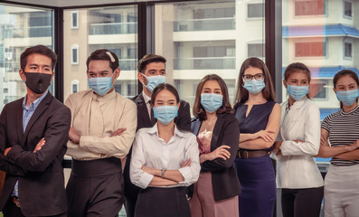 Group of young businesspeople mixed-sex including LGBT are wearing medical masks in the workplace in new normal situations preventing the infection of coronavirus or COVID-19...