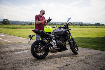 Obraz na płótnie Canvas A middle-aged man enjoys with his motorcycle