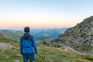 Men in the Vall de Riu lake from the Estanyo peak in Andorra in summer 2020.