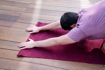 Mans hands on the yoga mat