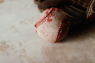 Baseball sport background with grunge used game ball and glove close up.