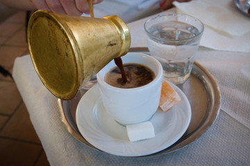 Delicious Bosnian coffee is served with rahat lokum dessert in traditional turkish coffee pot
