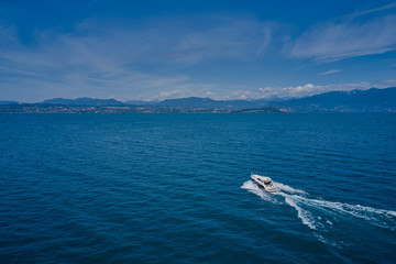 Top view of a white boat sailing in blue water. Motor boat in the lake. Travel - image