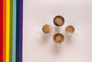 Cups with coffee on white with rainbow background