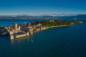 Panoramic aerial view early in the morning, Sirmione, an ancient village on southern Garda Lake, Italy. View by Drone. Rocca Scaligera Castle in Sirmione.
