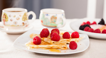 breakfast of pancakes with fresh raspberries on table