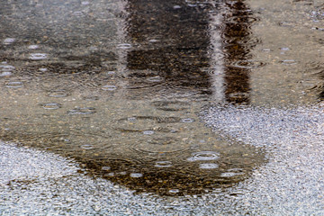 Rain falls on the road and creats puddles. Calgary, Alberta, Canada