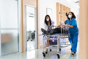 Fototapeta premium Group of Asian medics or doctors Push Stretcher with Seriously Patient to Operating Room, Emergency Department