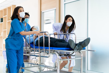 Group of Asian medics or doctors Push Stretcher with Seriously Patient to Operating Room, Emergency...