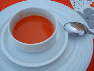 a cup of soup on a white plate