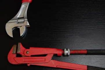 Wrenches on a black background. Metal tools for plumbing.