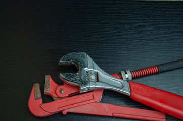 Wrenches on a black background. Metal tools for plumbing.