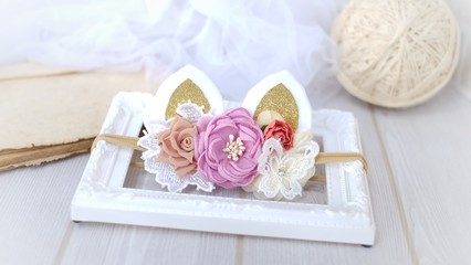 Handmade flowers as headband hair accessory with cat or kitty ears as decoration in soft pastel colors