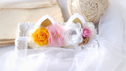 Handmade flowers as headband hair accessory with cat or kitty ears as decoration in soft pastel colors