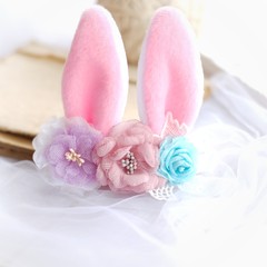 Obraz na płótnie Canvas Handmade flowers as headband hair accessory with bunny or rabbit ears as decoration in soft pastel colors