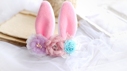 Fototapeta na wymiar Handmade flowers as headband hair accessory with bunny or rabbit ears as decoraiton in soft pastel colors