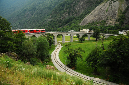 Switzerland - July 2012: Swiss Red Train Bernina Express pass on Brusio Viaduct, Italy & Switzerland.