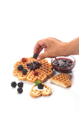 Girl served waffles with blueberry jam, Breakfast with coffee. White background, top view, close up