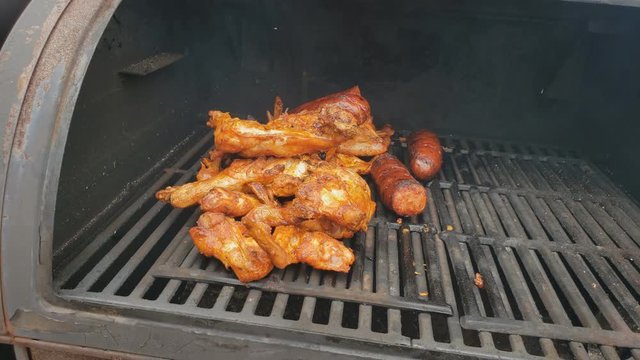 Home cooking - Chicken wings and sausage  being smoked for extra smoky flavor after previously cooked in gas grill.