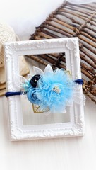 Headband flower with pastel color made out of flower fabric on a white photo frame. The handmade floral is great for hair accessories with its colorful flower and beautiful for hair band.