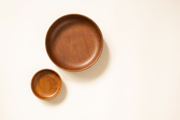 Empty wooden plates, top view. Craft round dishes on light beige background with copy space. Template for menu or recipe