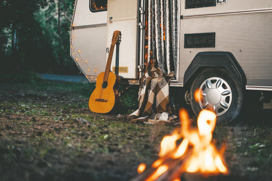 Camper van with gitar and fire place parking in forest at night