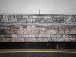 Fototapeta premium The empty wall of the subway station is lined with gray marble.