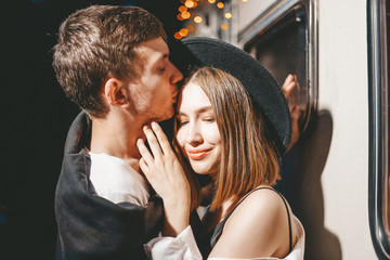 Obraz premium Young couple in love in stylish fashionable outfit romantic weekend wedding trip against background of camper in woods forest road trip