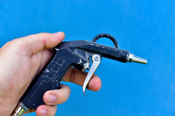 Gun for painting surfaces spray gun on a blue background
