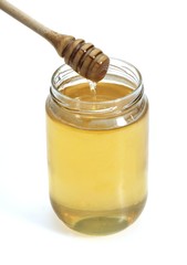 Jar of Honey with Honey Spoon against White Background