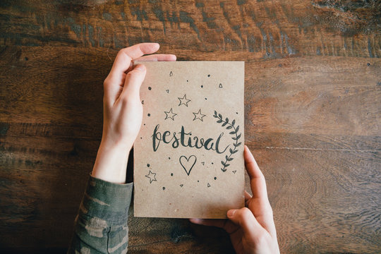 Hands holding paper with lettering