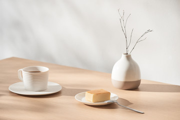 Still life with dried flower, hot tea, cheesecake and calendar on wooden table.