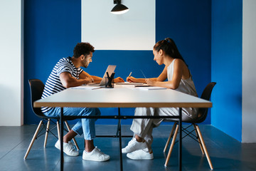 Young couple working at table with laptop