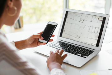 Crop event planner examining building scheme on laptop
