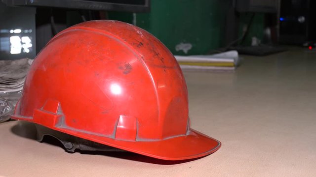 Safety concept,Red helmets were prepared for workers to wear before entering the construction area to prevent the danger of falling objects from working. Red safety helmet is placed on a wooden table.