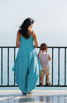 Mother with her son and looking at beautiful sea views from a balcony