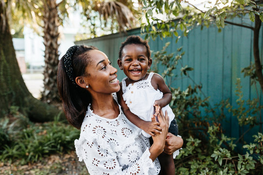 A smiling candid photo of a mother and her young daughter.