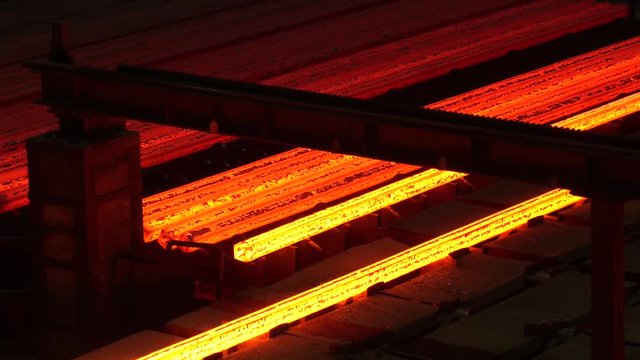 Red hot steel metal billets after molten steel casting. Continuous casting machine. Heavy industry metallurgical plant continuous casting machine
