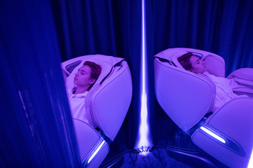 Young woman relaxing in massage chair