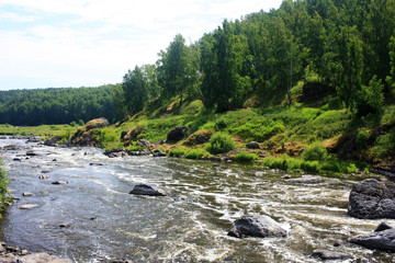 Stone boulders lie in a mountain river