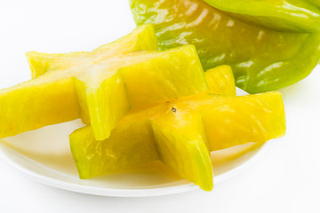 Sliced carambola on a white dish, it is a sweet and juicy fruit.