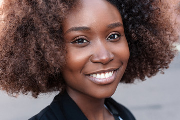 Pretty young black african american woman street closeup smiling portrait.