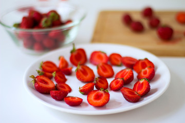 
Sliced ​​strawberries on  plate on  white background. 
Diet food, vegan menu, homemade cake ingredients.