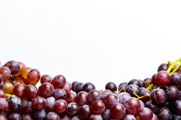 Close-up of red seedless grapes with water droplets on a white background.