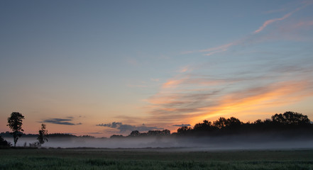 Sonnenaufgang im Nebel über dem Feld