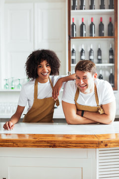 Cheerful diverse waiters working behind counter