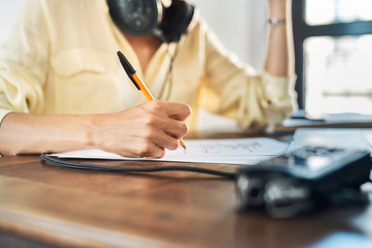 Crop podcaster writing script at home