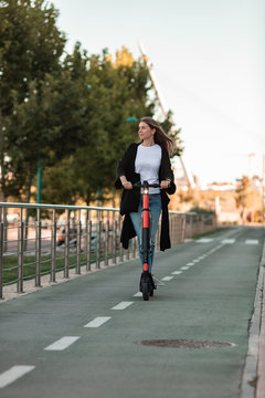 Woman taking a ride with an electric scooter in the city.