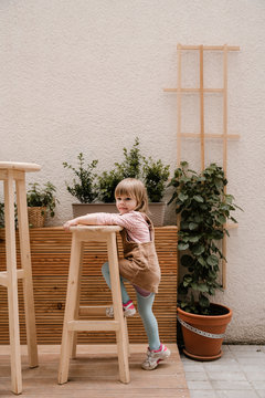 Young Little Girl stepping on Wooden Stool