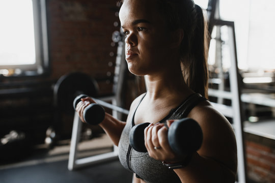 Dwarf woman goes in for sport and makes exercise with dumbbells.